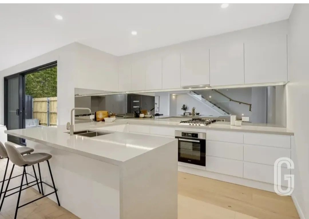 Bar Beach — Kitchen with mirrored splashback and stone benchtops